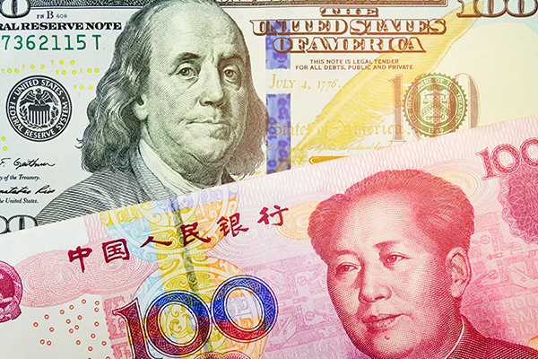 Close up of the U.S. dollar and Chinese yuan bills, photo by Sutthipong Kongtrakool/Getty Images
 