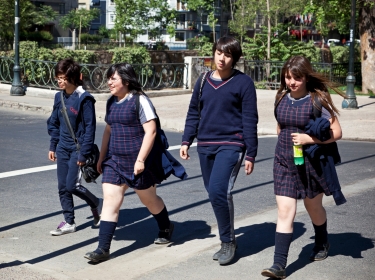 Santiago, Chile - November 14, 2011: Young woman students of high school walking down a street from school. Lya Cattel/iStock