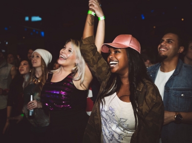 Group of women dancing at a concert, photo by Hero Images/Getty Images