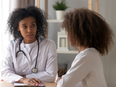 Female doctor talking with teenage girl, photo by fizkes/Getty Images