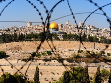 View from the Mount of Olives to the Dome of the Rock, through barbed wire, photo by gkuna/Adobe Stock