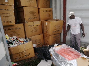 An agent stands next to a container full of illegal and false drugs seized by Ivorian authorities in Abidjan, Ivory Coast, November 6, 2018, photo by Luc Gnago/Reuters