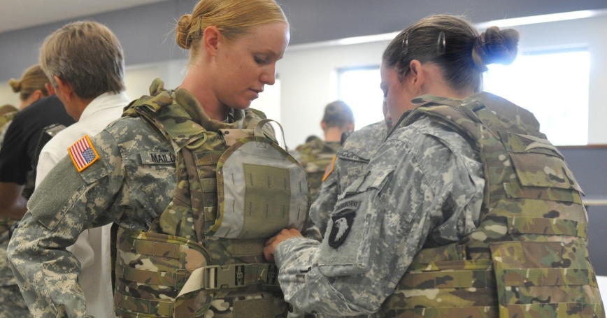 A soldier gets help adjusting her protoype Generation III Improved Outer Tactical Vest at Fort Campbell, Kentucky