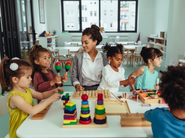 Teacher and children in a preschool classroom, photo by bernardbodo/Getty Images