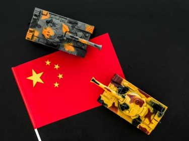 War, military threat, military power concept. China. Tanks toy near chinese flag on black background top view, photo by 9dreamstudio/AdobeStock