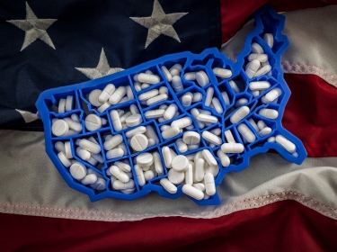 Healthcare, opioid epidemic and drug abuse concept with the map of USA filled with oxycodone and hydrocodone pharmaceutical pills on the American flag, photo by Victor Moussa/AdobeStock