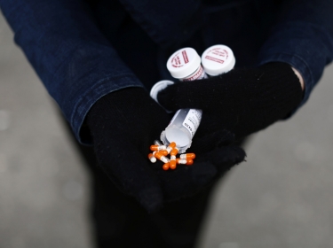 A fentanyl user displays a "safe supply" of opioid alternatives, including morphine pills, provided by the local health unit in Vancouver, Canada, April 6, 2020, photo by Jesse Winter/Reuters