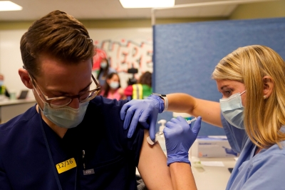 Mahasiswa kedokteran tahun keempat Anna Roesler memberikan vaksin penyakit coronavirus (COVID-19) Pfizer-BioNTech di Indiana University Health, Methodist Hospital di Indianapolis, Indiana, AS, 16 Desember 2020, foto oleh Bryan Woolston/Reuters