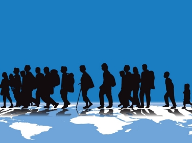 An illustration of migration using silhouettes of people walking across the globe. Image by Carlos Gardel / Adobe Stock