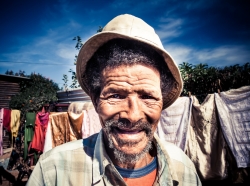 adult,africa,african,aged,aging,alone,background,beard,black,day,elderly,expression,eyes,face,friendly,grey,guy,hair,happy,hat,human,joy,life,male,man,old,outdoor,person,poor,poverty,rural,senior,shirt,smile,toothless,vibrant,wrinkles