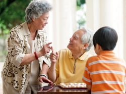Grandparents teaching their grandson how to play Xiangqi, Chinese chess