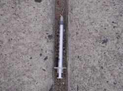 A needle used for shooting heroin and other opioids litters the ground on a sidewalk in the Kensington section of Philadelphia, Pennsylvania, October 26, 2017, photo by Charles Mostoller/Reuters