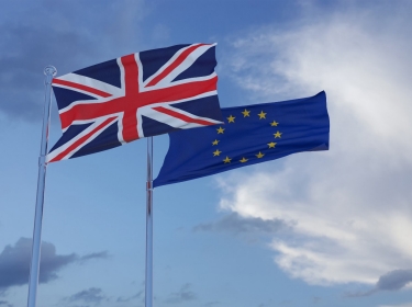 British and European Union flags in a cloudy sky, photo by themotioncloud/Getty Images