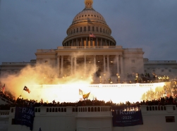 An explosion caused by a police munition is seen while supporters of U.S. President Donald Trump gather in front of the U.S. Capitol Building in Washington, D.C., January 6, 2021, photo by Leah Millis/Reuters