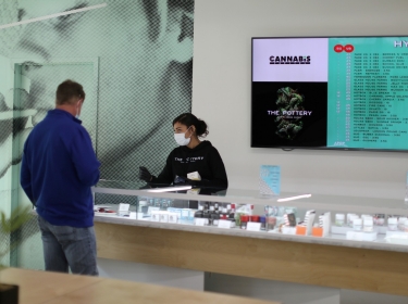 Ashlee Mason, 26, serves a customer at The Pottery Cannabis Dispensary, as cannabis deliveries increase amid the spread of COVID-19, in Los Angeles, California, April 14, 2020, photo by Lucy Nicholson/Reuters