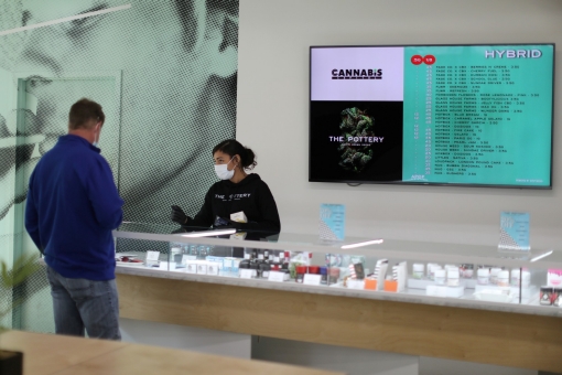 Ashlee Mason, 26, serves a customer at The Pottery Cannabis Dispensary in Los Angeles, California, April 14, 2020