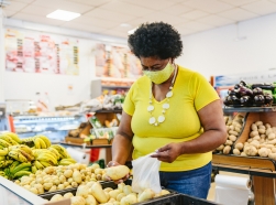 Woman in the grocery store buying produce, photo by Igor Alecsander/Getty Images