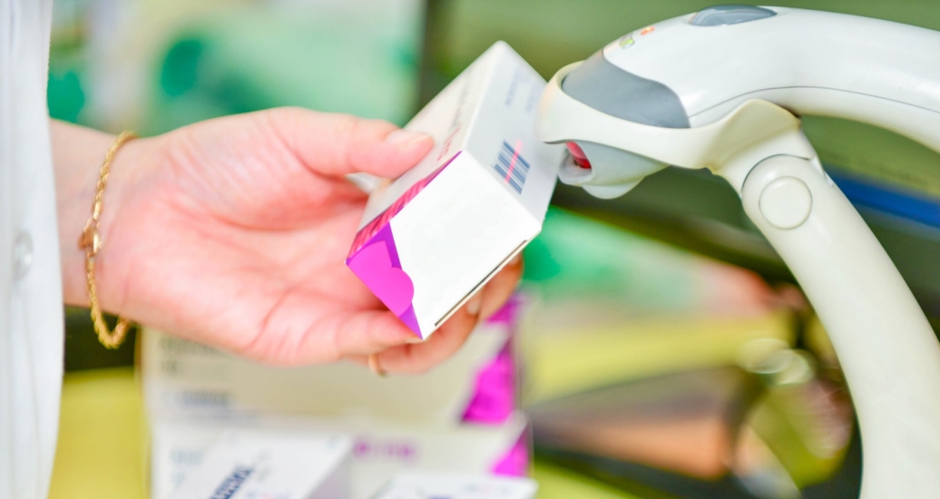 A pharmacist scanning a bar code on a box of prescription medication