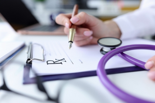 Closeup of a hand writing a prescription