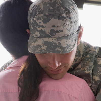 Soldier leaning on woman's shoulder