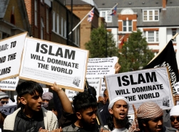 Muslims hold placards as they march towards the U.S. embassy in London, May 2011