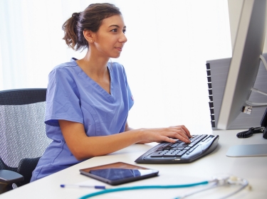 Doctor working at office computer, photo by Monkey Business/Adobe Stock