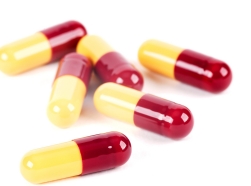 Red and yellow capsules on white background