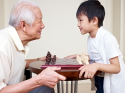 Grandpa and grandson playing a chess game