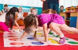 Young children play Twister in the classroom