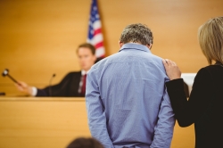 A man and his lawyer hear a ruling from a judge