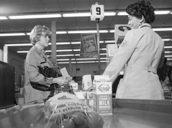 A shopper uses food stamps at a grocery store in March 1970