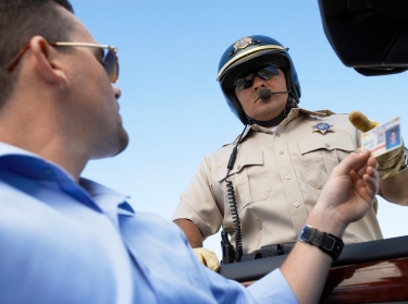 Man handing drivers license to officer