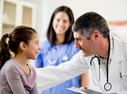 Child and doctor, with nurse in the background