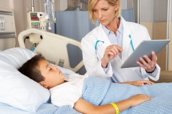 Doctor Using Digital Notepad While Visiting Child Patient