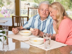 Senior man and adult daughter enjoying time together over lunch