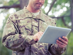 A soldier using a tablet outside