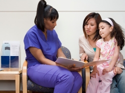 Nurse talking with mother and daughter in waiting room