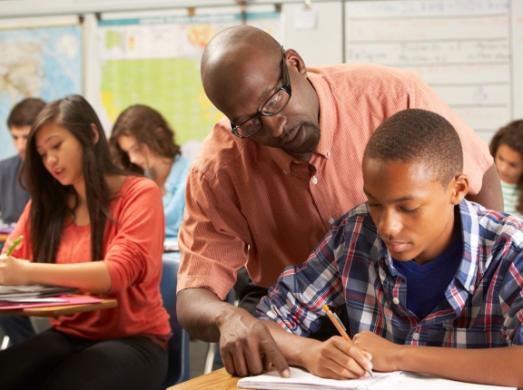 African American teacher helping high school student in the classroom