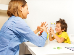 Teacher working with young boy at a table