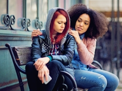 A teen girl comforts her depressed friend