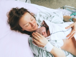 Mother holding her newborn baby immediately after giving birth in the hospital