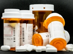 Loose pills in front of prescription bottles