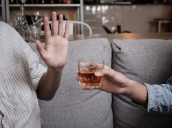 Close up hand rejecting glass of alcohol, photo by KomootP/Adobe Stock