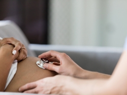 Close up of a nurse using a stethoscope to conduct a prenatal check on a pregnant woman, photo by SDI Productions/Getty Images