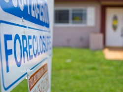 A foreclosure sign outside a house. Photo by Reicaden / Getty Images