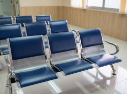 Rows of blue chairs in a waiting room, photo by Mumemories/Getty Images