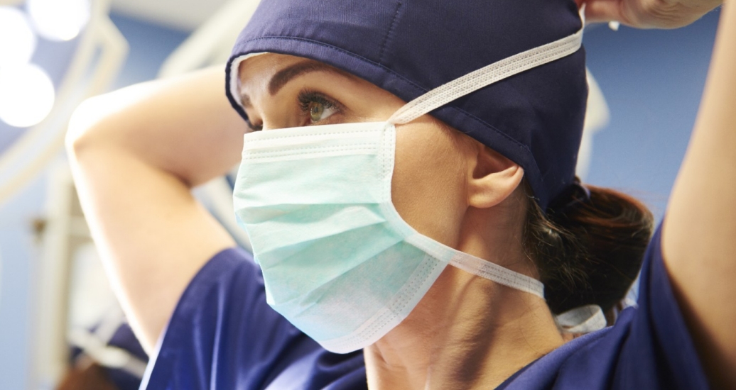 A female surgeon putting on her mask