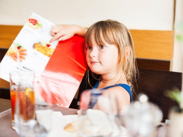 Girl pointing to her meal choice on a restaurant menu