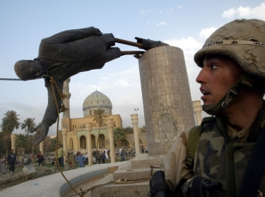 U.S. marine watches as a 20-foot high statue of Iraq's President Saddam Hussein falls in central Baghdad in April 2003