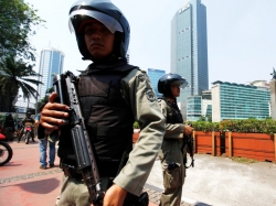 Indonesian anti-terror policemen hold their rifle as they stand guard at the business district in Jakarta, September 11, 2011